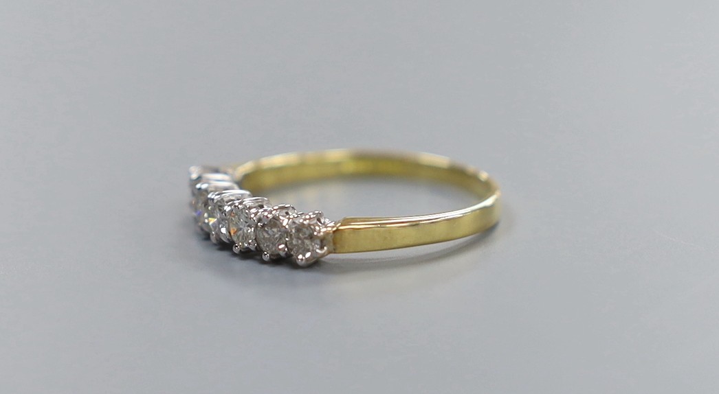 A modern 18ct gold and seven stone diamond set half hoop ring, size P/Q, gross weight 2.6 grams
